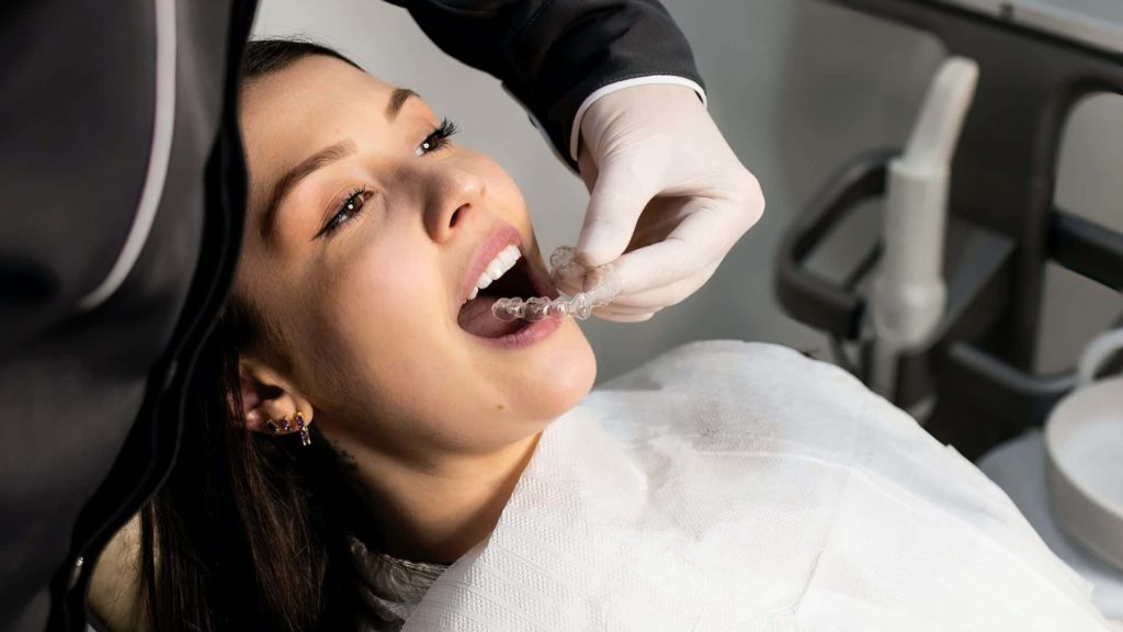Woman about to fit invisible braces How to Choose the Right Clear Braces